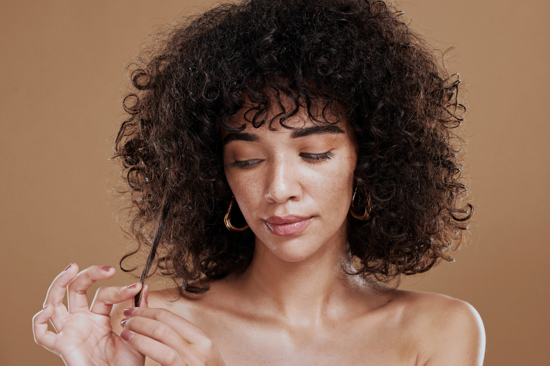 Curly hair being handled gently to support healing and rebuild healthy routines