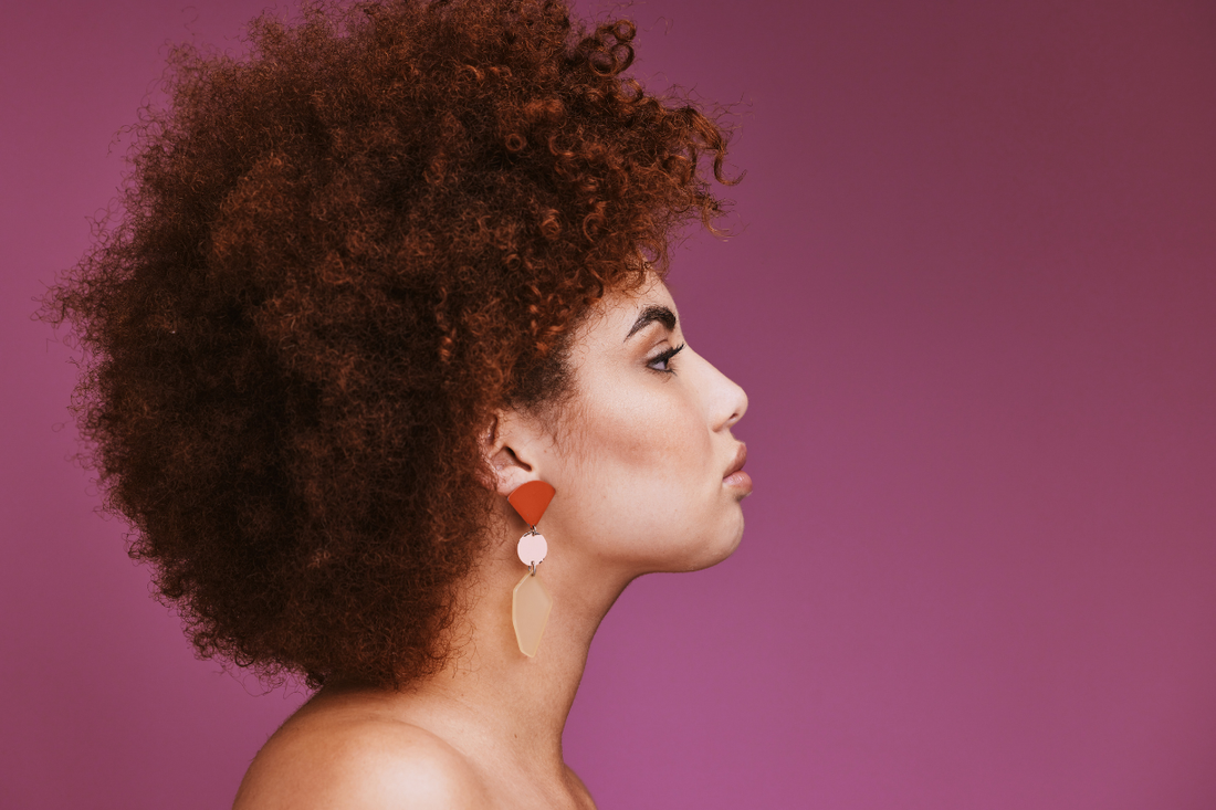 Woman with voluminous color-treated curly hair, highlighting healthy-looking texture and definition