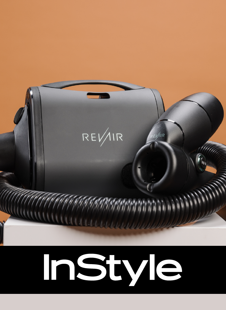 RevAir Reverse-Air Dryer unit and wand displayed on a white surface against a warm terracotta background, with the InStyle logo displayed below