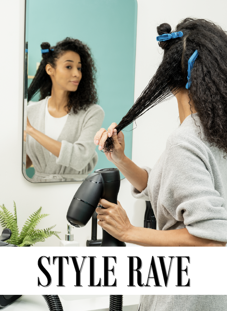 A woman with curly hair sectioned with blue clips using the RevAir Reverse-Air Dryer wand in front of a bathroom mirror, with the Style Rave logo displayed below
