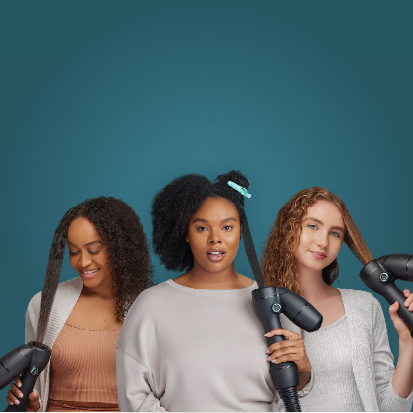 Group of three diverse women all using the RevAir Reverse-Air Dryer to dry and stretch their hair